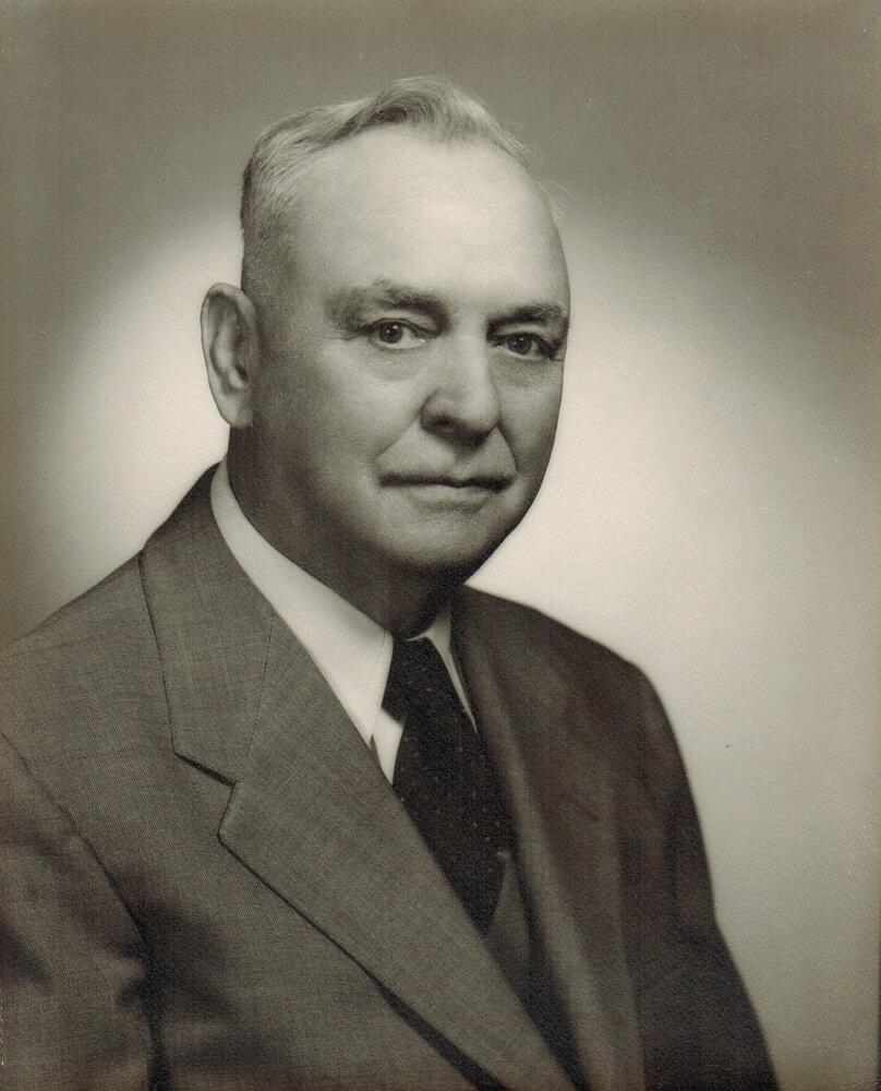 A black and white image of W Pearl Garrett wearing a light color suit and tie.