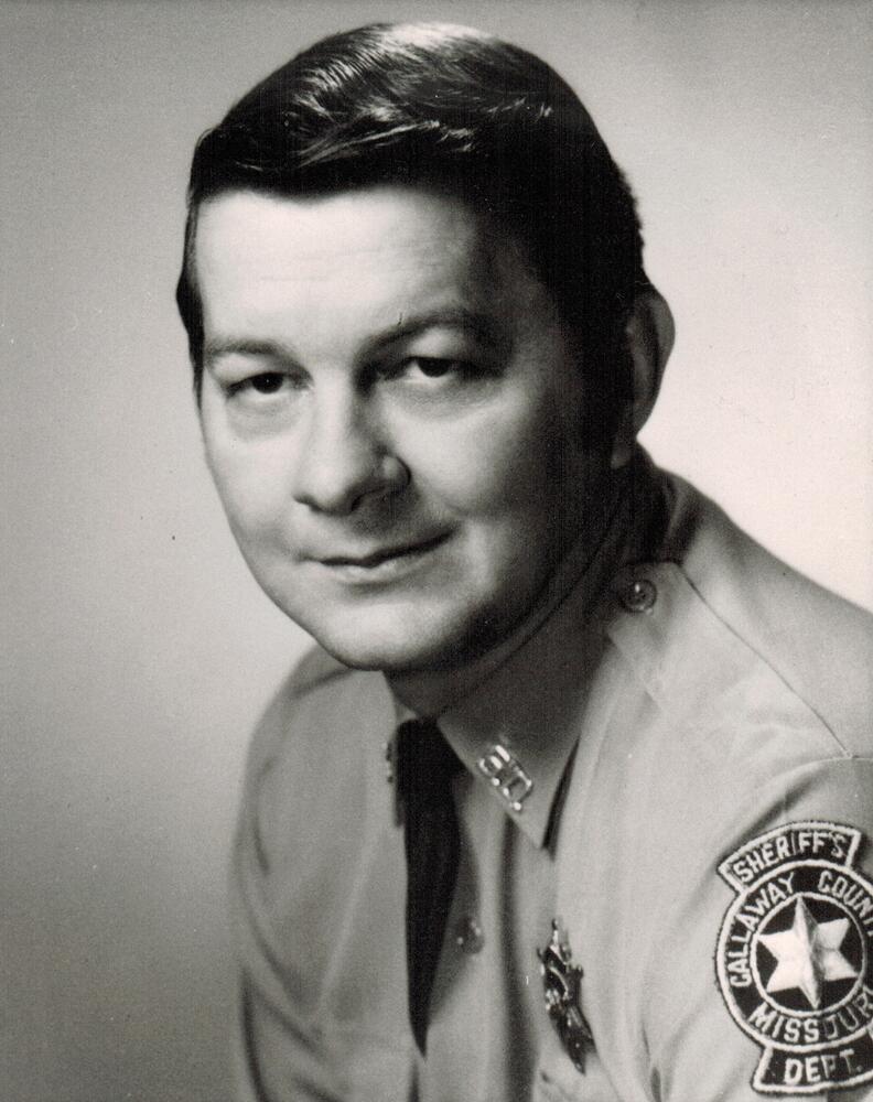 A black and white image of Ted Salmons wearing a Sheriff's Office uniform.