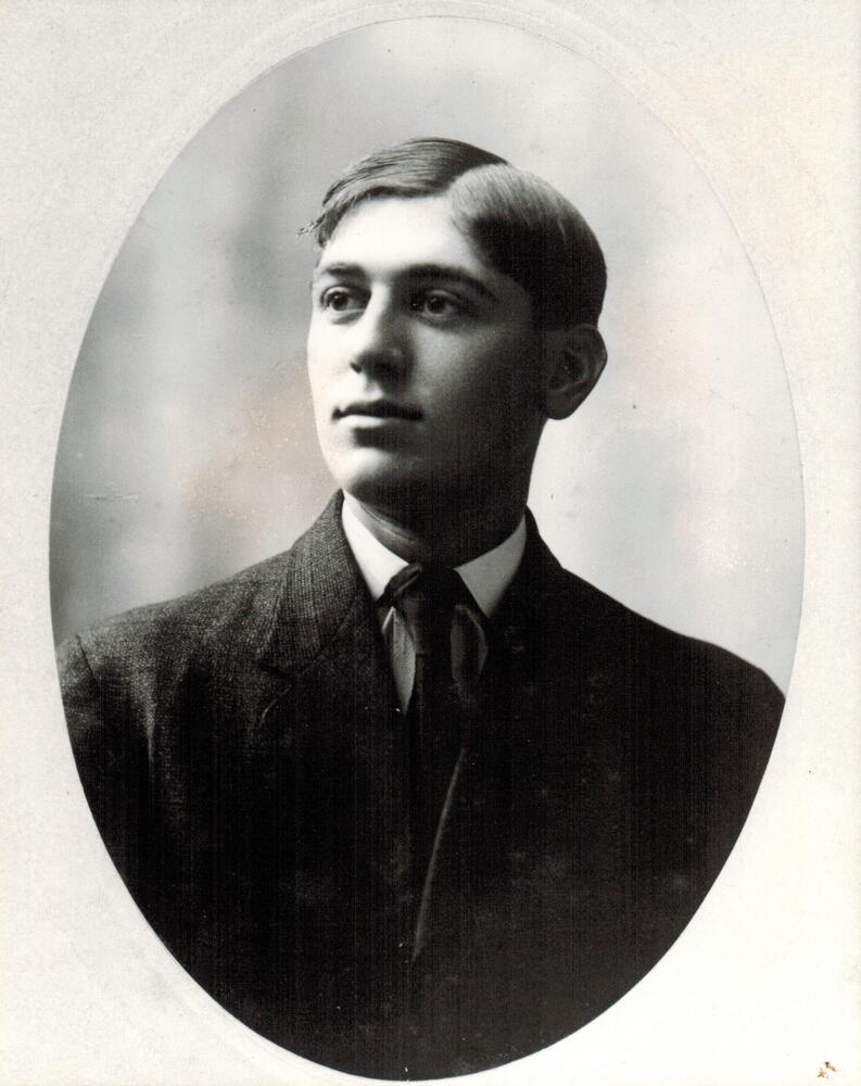 A black and white image of Jack Selby.  Selby is wearing a dark suit.