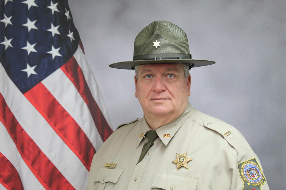 Lt Bill Akers pictured in front of an American Flag.