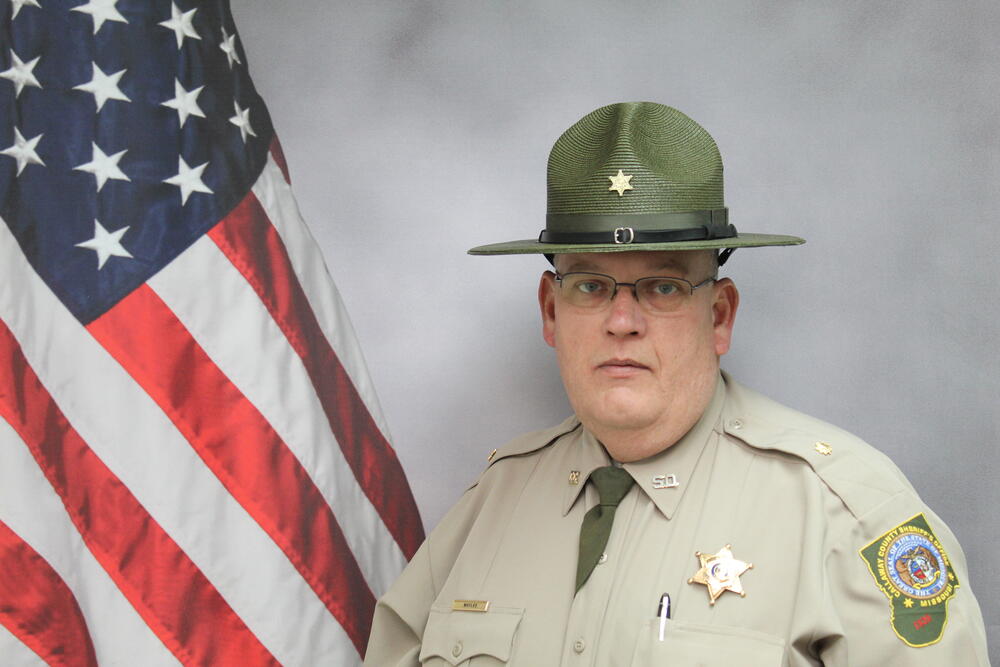 Major Darryl Maylee pictured in front of an American Flag.