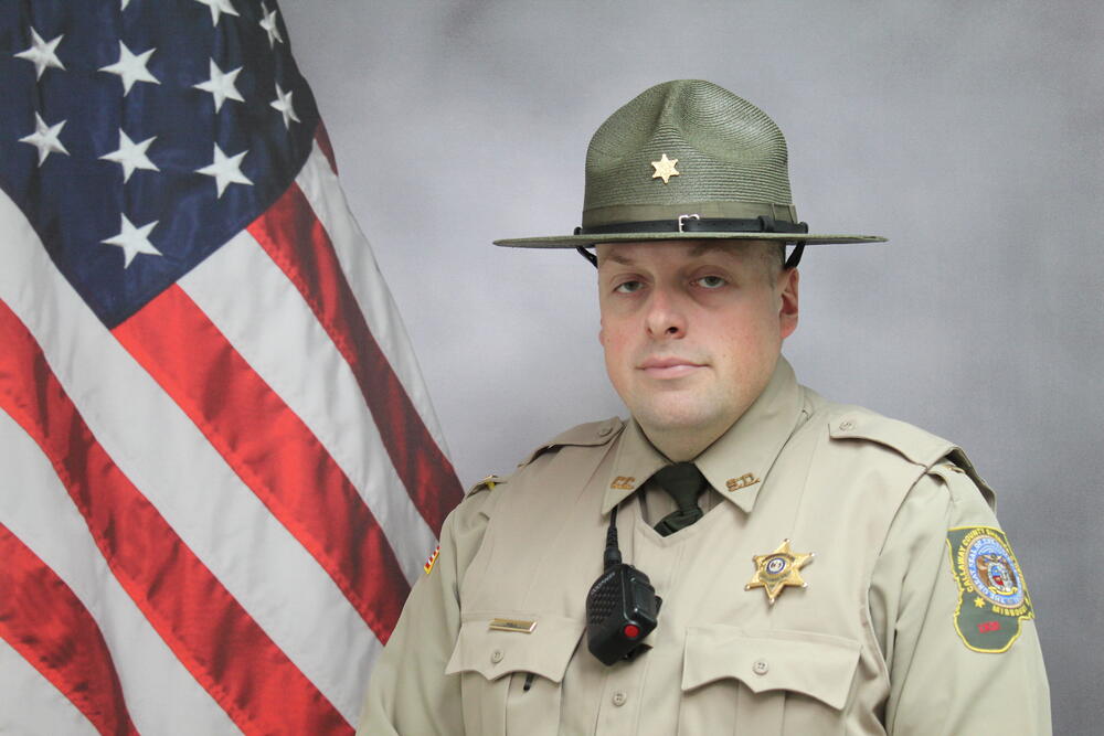 Lt Curtis Hall pictured in front of an American Flag.