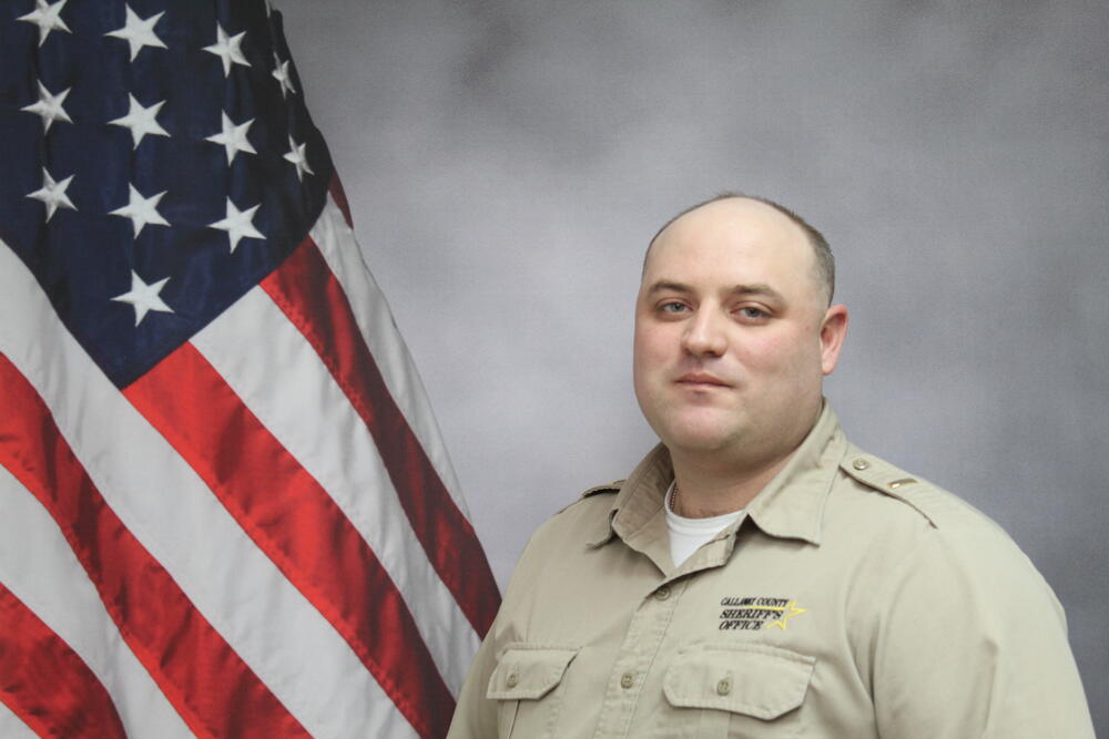 Lt Lucas Stassel pictured in front of an American Flag.