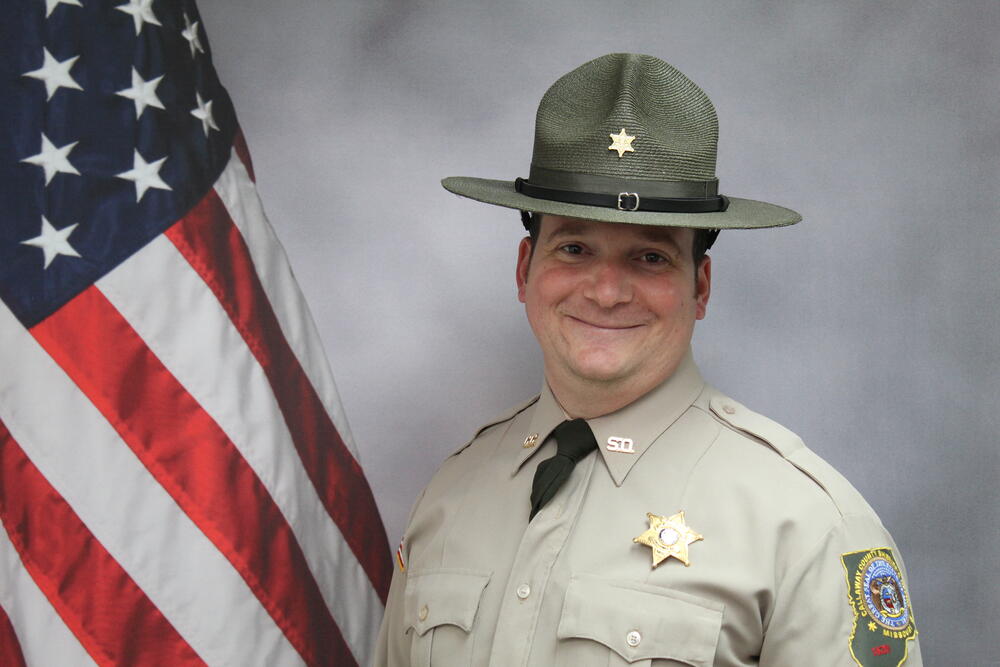 Lieutenant Blake Atkins in uniform with in front of an American flag.