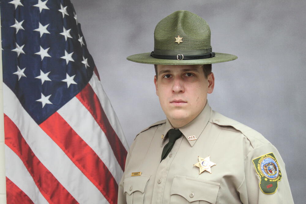 Deputy TJ Genson pictured in front of an American Flag.