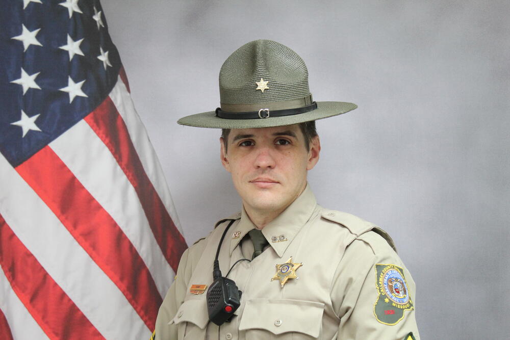 Sgt Billy Kamp pictured in front of an American Flag.