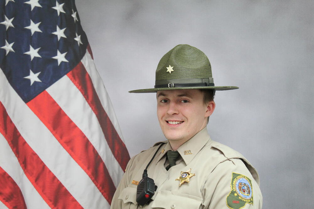 Deputy Nathan Lexa pictured in front of an American Flag.