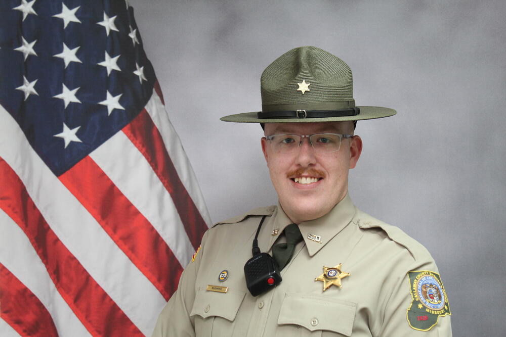 Deputy Jacob Muehring pictured in front of an American Flag.