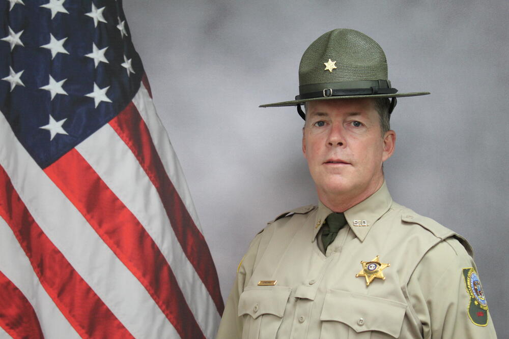 Deputy Daniel O'Rourke pictured in front of an American Flag.