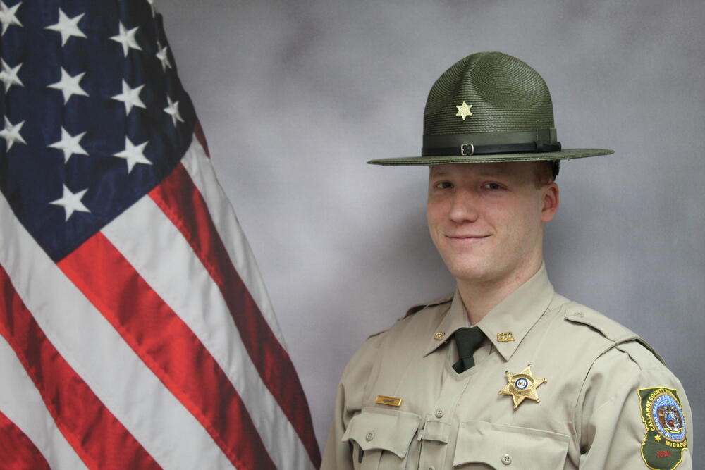 Deputy Zach Hubbard pictured in front  of an American Flag.