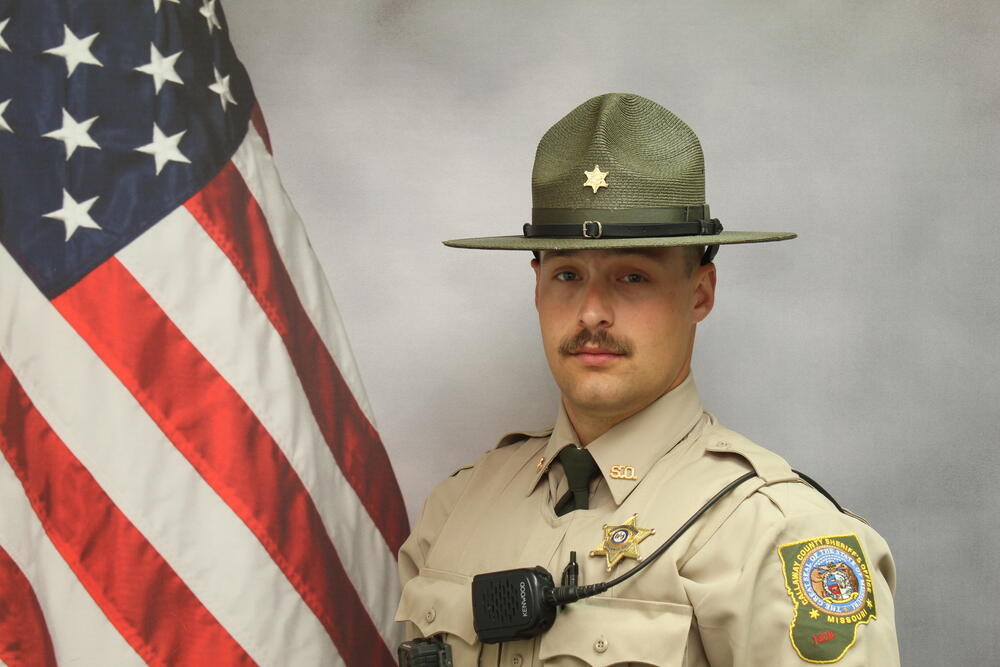 Deputy Jesse Bohannon pictured in front of an American Flag.