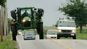 Traffic stuck behind a farm tractor.