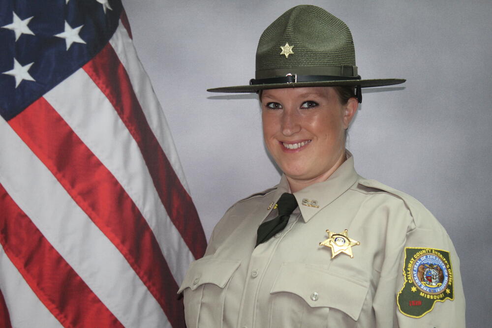 Sgt Crystal Kent pictured in uniform in front of an American flag.