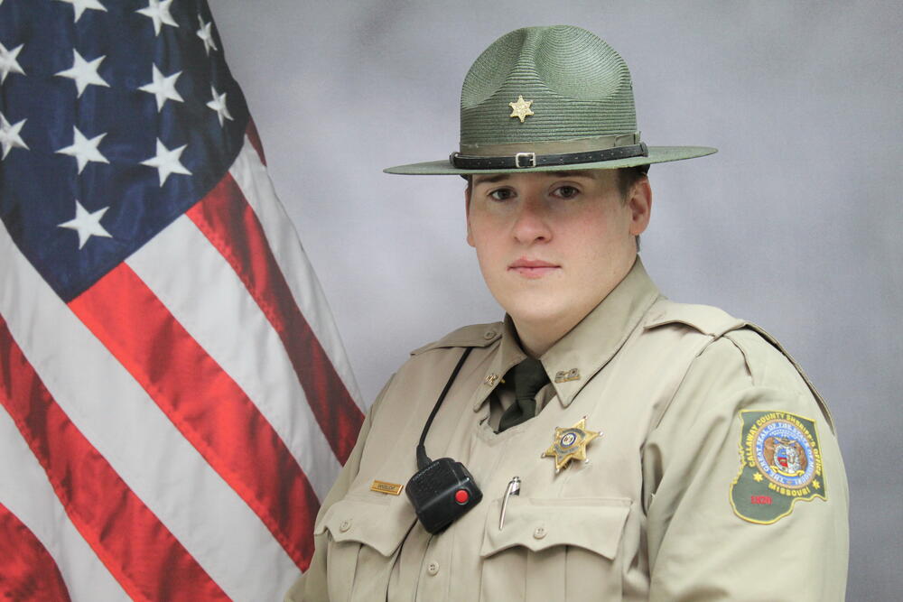 Deputy Cody Vandelicht pictured in uniform in front of an American Flag.