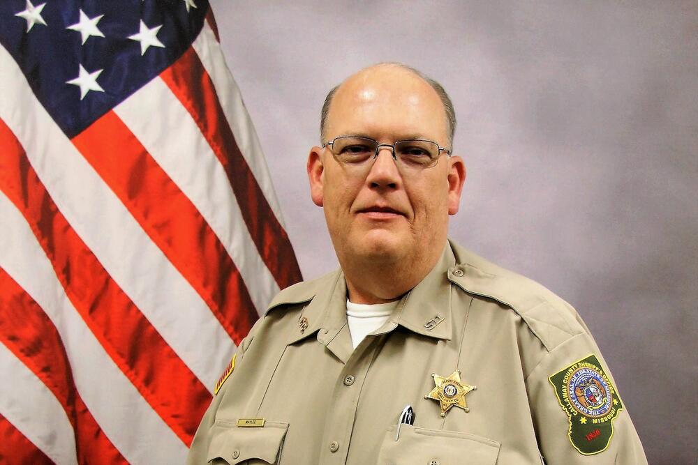 Sheriff Darryl Maylee pictured in uniform in front of an American Flag