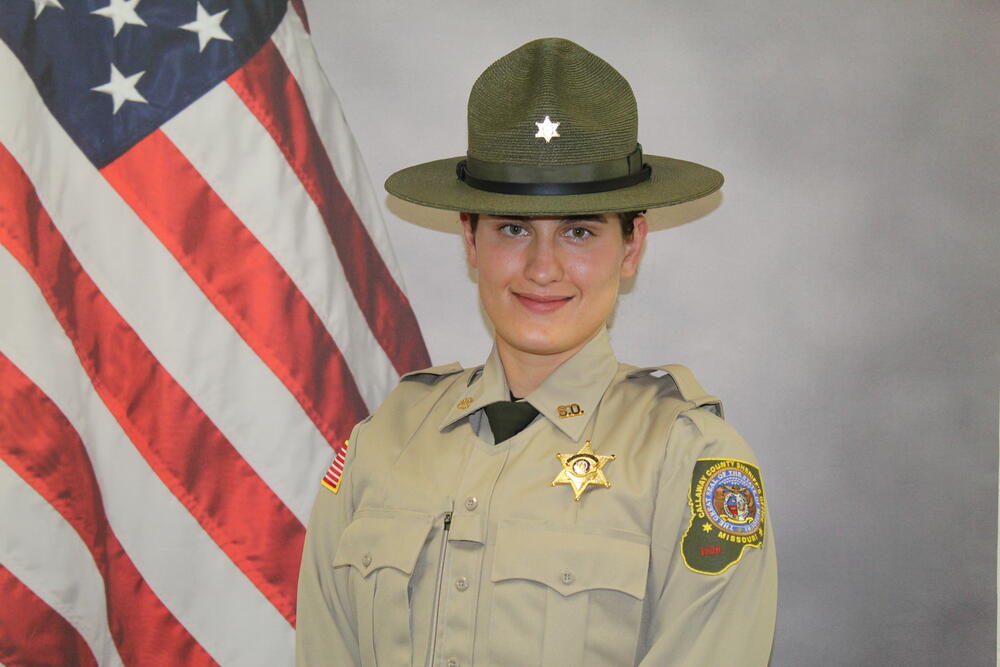 Deputy Shianne Reno pictured in uniform in front of an American Flag.