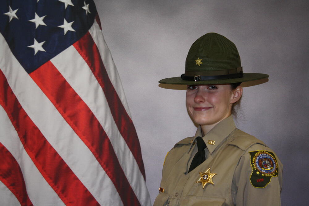 Deputy Alyssa Deuel in uniform in front of an American Flag.